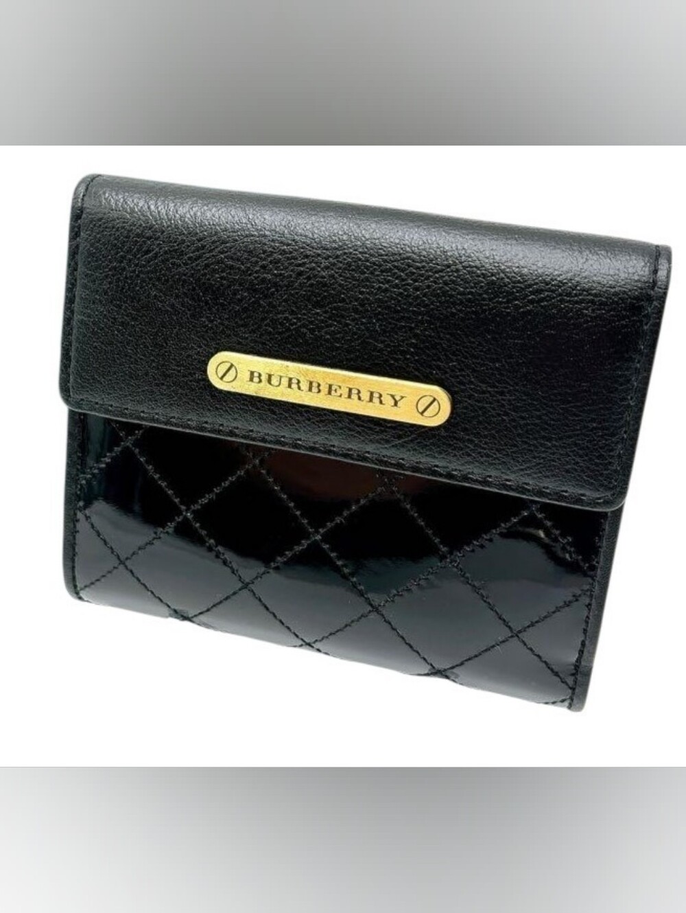 Burberry black quilted leather bifold wallet featuring a sleek gold-tone metal